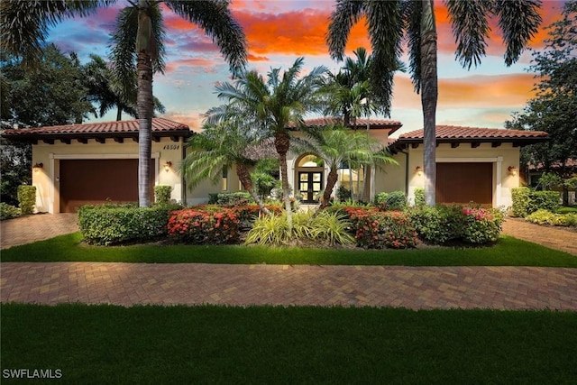 14501 Marsala Way, Naples, FL 34109 - mediterranean / spanish-style house with stucco siding, a tiled roof, a garage, and decorative driveway