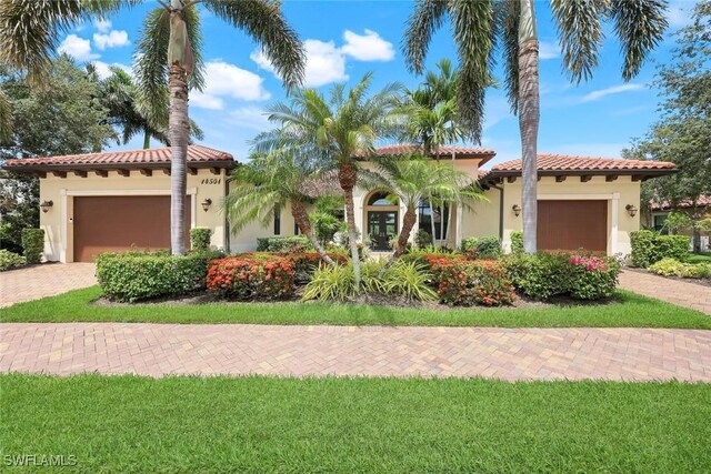 14501 Marsala Way, Naples, FL 34109 - mediterranean / spanish-style house featuring stucco siding, a tile roof, an attached garage, and decorative driveway