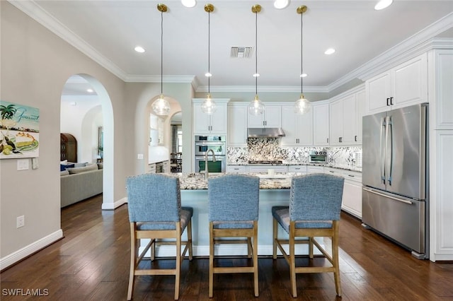 14501 Marsala Way, Naples, FL 34109 - kitchen with appliances with stainless steel finishes, under cabinet range hood, white cabinets, backsplash, and dark wood-style flooring