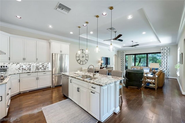 14501 Marsala Way, Naples, FL 34109 - kitchen featuring appliances with stainless steel finishes, a raised ceiling, a ceiling fan, white cabinets, and open floor plan