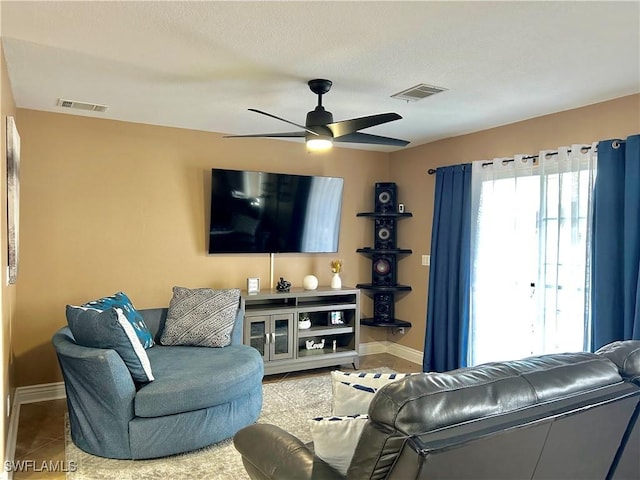 living room featuring ceiling fan, baseboards, and visible vents