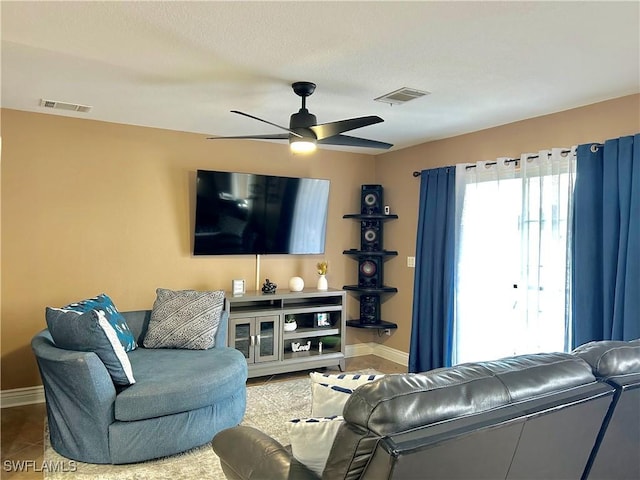 living area with visible vents, baseboards, and ceiling fan