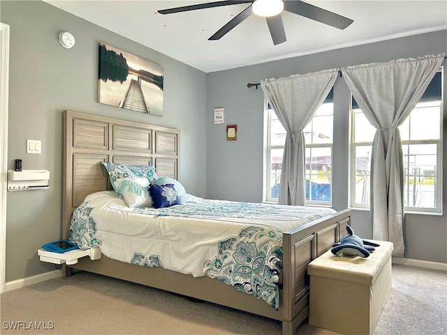 carpeted bedroom featuring baseboards and ceiling fan