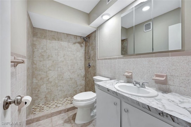 547 103rd Ave N, Naples, FL 34108 - bathroom with tile walls, a tile shower, toilet, vanity, and tile patterned floors