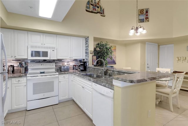1150 Wildwood Lakes Blvd Unit 306, Naples, FL 34104 - kitchen with light tile patterned floors, white appliances, a peninsula, and a sink