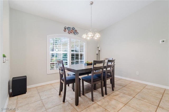 dining area with light tile patterned floors, lofted ceiling, a chandelier, and baseboards
