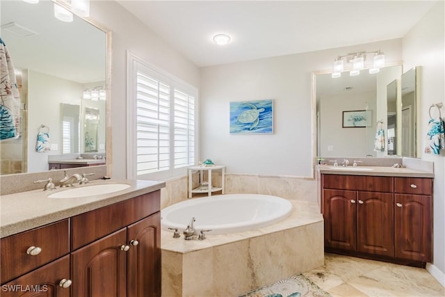full bath with two vanities, a bath, and a sink