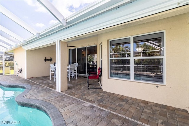 outdoor pool featuring a patio area and glass enclosure