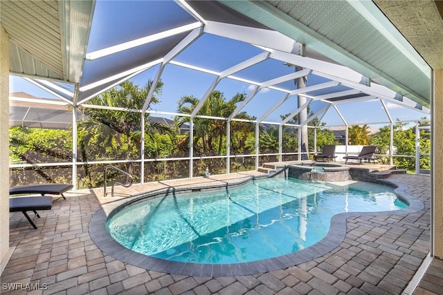view of swimming pool with a patio area, glass enclosure, and a pool with connected hot tub