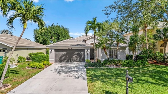 2325 Heritage Greens Dr, Naples, FL 34119 - view of front of house featuring stucco siding, an attached garage, concrete driveway, and a front lawn