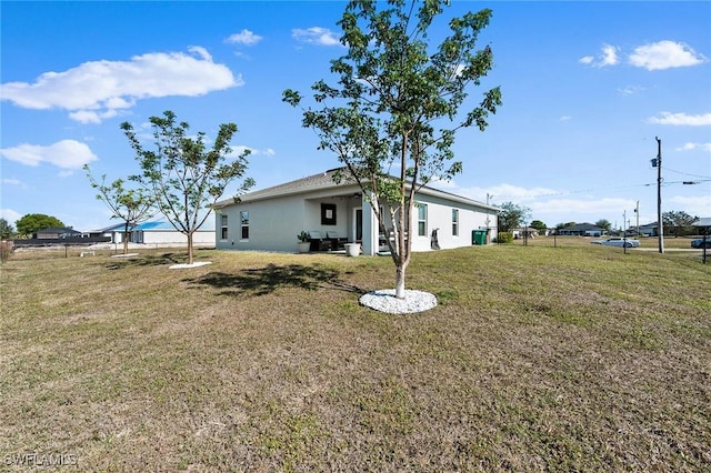 2112 NE 4th Place, Cape Coral, FL 33909 - back of property featuring a lawn and stucco siding