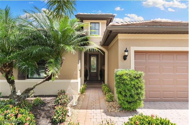 property entrance with stucco siding and a garage