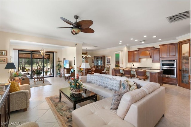 living room featuring recessed lighting, visible vents, ornamental molding, light tile patterned floors, and ceiling fan with notable chandelier