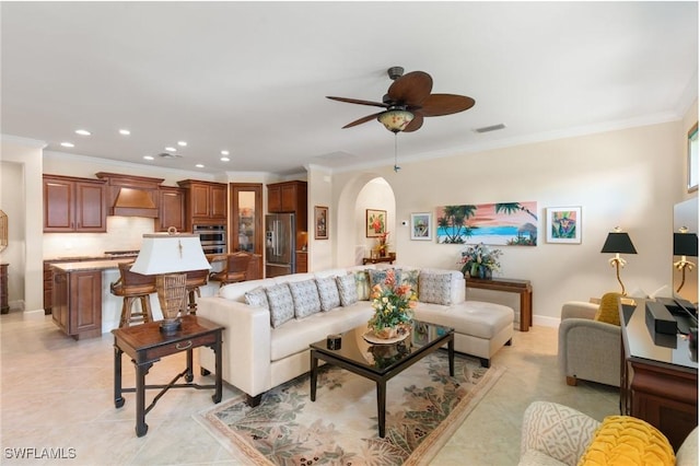 living room with arched walkways, visible vents, crown molding, and ceiling fan