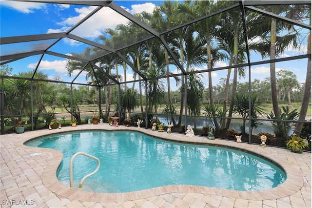 outdoor pool featuring glass enclosure, a water view, and a patio