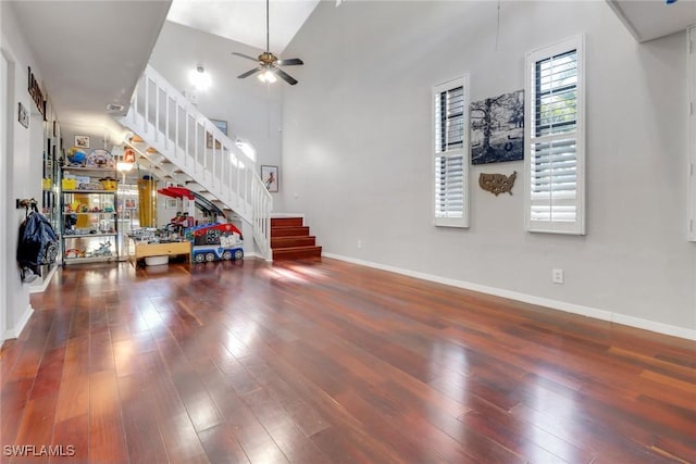 living area with ceiling fan, hardwood / wood-style flooring, and stairway