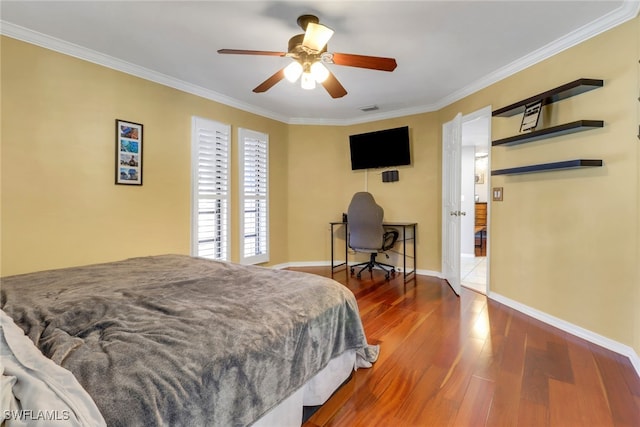 bedroom with crown molding, a ceiling fan, wood-type flooring, baseboards, and visible vents