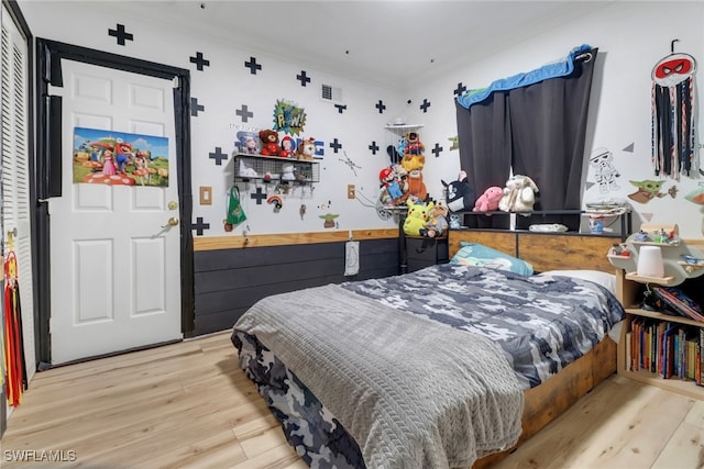 bedroom with wood finished floors and ornamental molding
