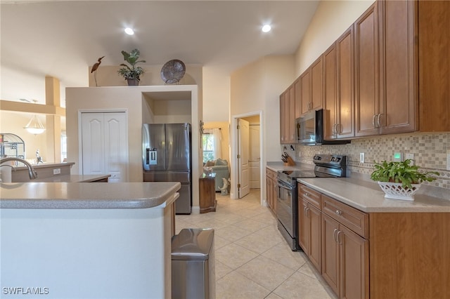 26 NW 29th Pl, Cape Coral, FL 33993 - kitchen featuring tasteful backsplash, light countertops, light tile patterned flooring, brown cabinetry, and appliances with stainless steel finishes
