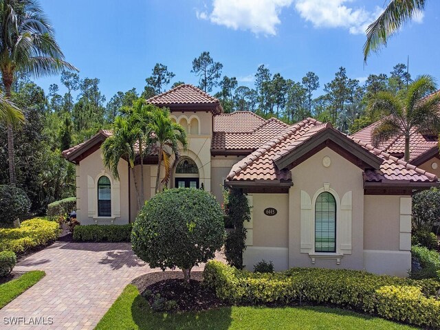 mediterranean / spanish house with a tile roof and stucco siding