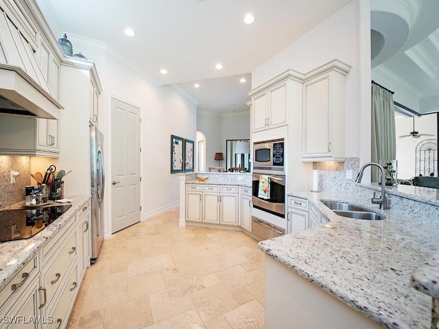 kitchen with recessed lighting, a peninsula, crown molding, appliances with stainless steel finishes, and a sink