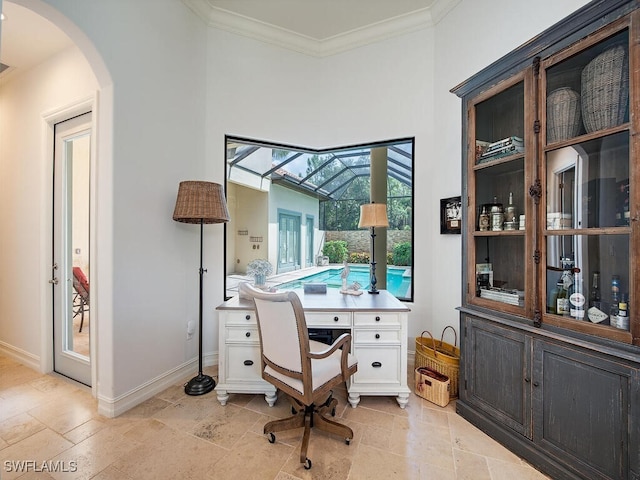 office with crown molding, baseboards, and arched walkways