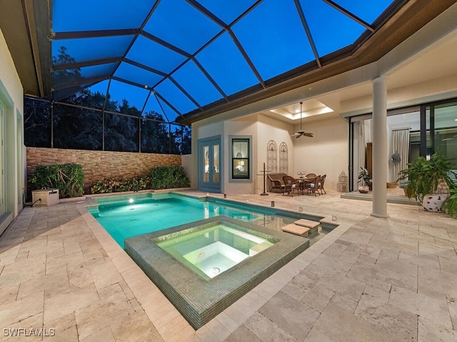view of swimming pool with a patio area, ceiling fan, a pool with connected hot tub, glass enclosure, and outdoor dining area