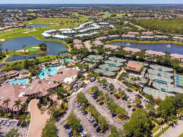 drone / aerial view featuring golf course view, a residential view, and a water view