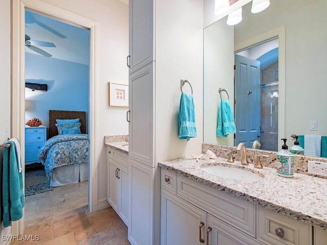ensuite bathroom with vanity, an enclosed shower, a ceiling fan, connected bathroom, and stone finish flooring