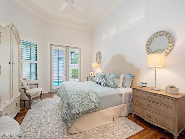 bedroom featuring access to outside, dark wood-style flooring, ornamental molding, and a raised ceiling