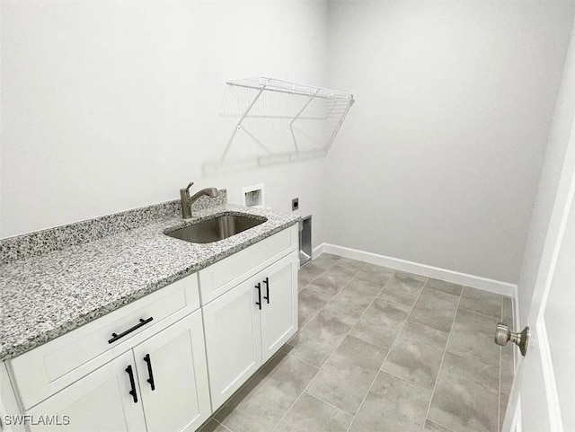 laundry area featuring baseboards, electric dryer hookup, washer hookup, cabinet space, and a sink