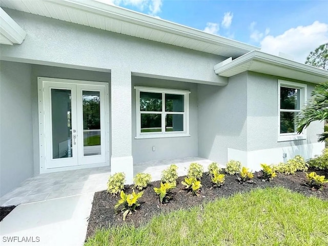 property entrance featuring french doors and stucco siding