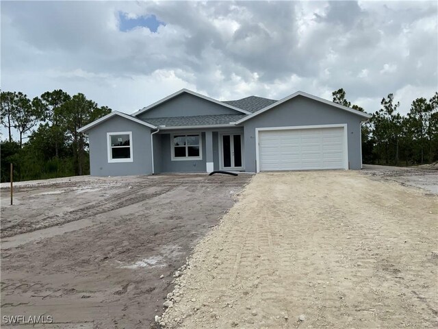 2864 68th Ave NE, Naples, FL 34120 - view of front of property with an attached garage, stucco siding, and dirt driveway