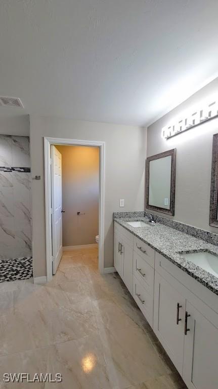 1138 Argosy Rd, Labelle, FL 33935 - full bathroom with marble finish flooring, tiled shower, double vanity, toilet, and baseboards
