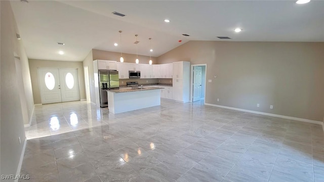 1138 Argosy Rd, Labelle, FL 33935 - kitchen featuring appliances with stainless steel finishes, open floor plan, white cabinets, a center island with sink, and baseboards