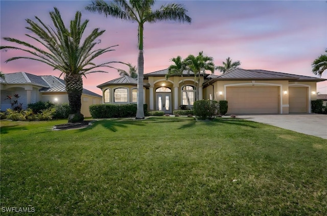 144 SW 54th Ter, Cape Coral, FL 33914 - mediterranean / spanish house featuring a standing seam roof, an attached garage, stucco siding, concrete driveway, and a front yard