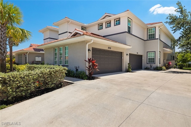12000 Santaluz Dr Unit 202, Fort Myers, FL 33913 - view of front of property with a garage, a tiled roof, driveway, and stucco siding