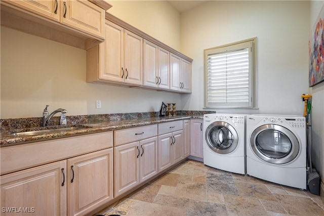 laundry room with cabinet space, stone tile flooring, independent washer and dryer, and a sink