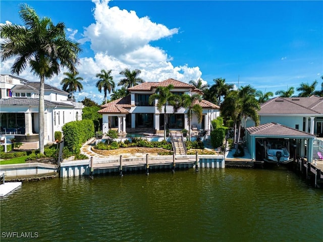 back of house featuring an outdoor pool, a patio, a tiled roof, and a water view