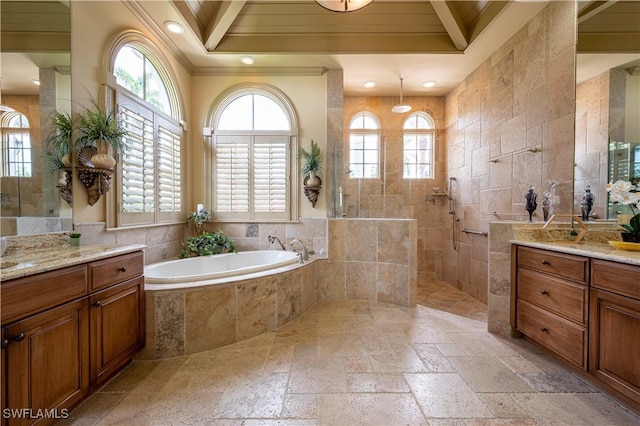 full bathroom with walk in shower, stone tile flooring, crown molding, vanity, and a garden tub