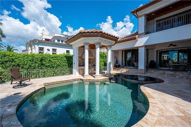 view of pool with a patio area, fence, a ceiling fan, and exterior fireplace