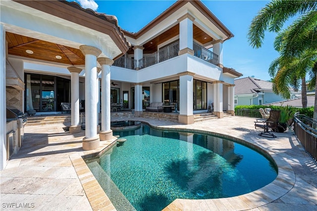 rear view of property with a fenced in pool, a patio area, a balcony, and ceiling fan