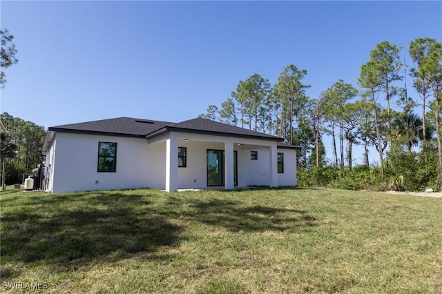 3314 43rd St W, Lehigh Acres, FL 33971 - rear view of property featuring a yard and stucco siding