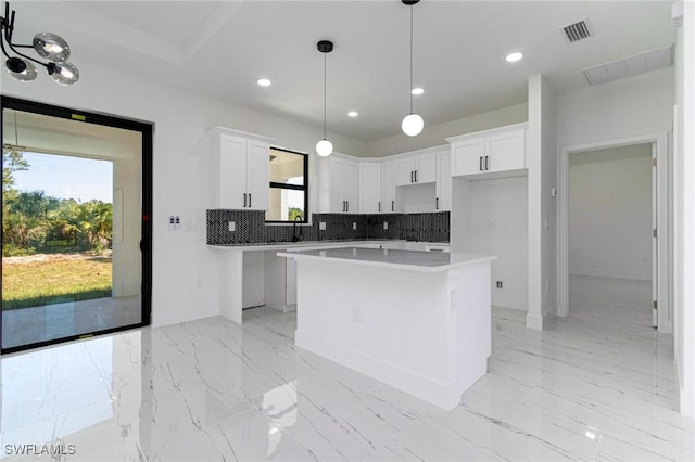 3314 43rd St W, Lehigh Acres, FL 33971 - kitchen with a healthy amount of sunlight, decorative backsplash, visible vents, and a kitchen island