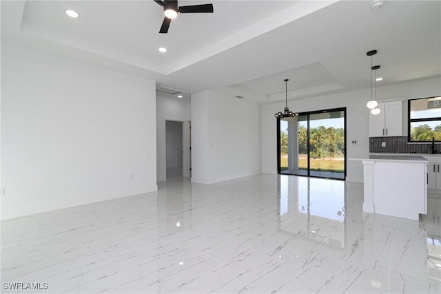 3314 43rd St W, Lehigh Acres, FL 33971 - empty room featuring a tray ceiling, recessed lighting, marble finish floor, and ceiling fan with notable chandelier