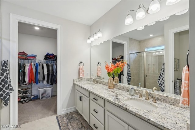 847 Stonewater Lake Ter, Cape Coral, FL 33993 - full bathroom with a stall shower, a spacious closet, tile patterned floors, double vanity, and baseboards