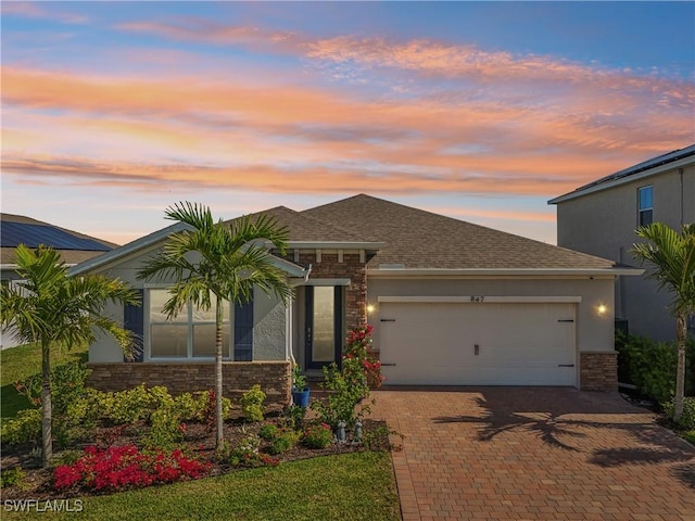 847 Stonewater Lake Ter, Cape Coral, FL 33993 - view of front facade featuring an attached garage, decorative driveway, stone siding, and roof with shingles
