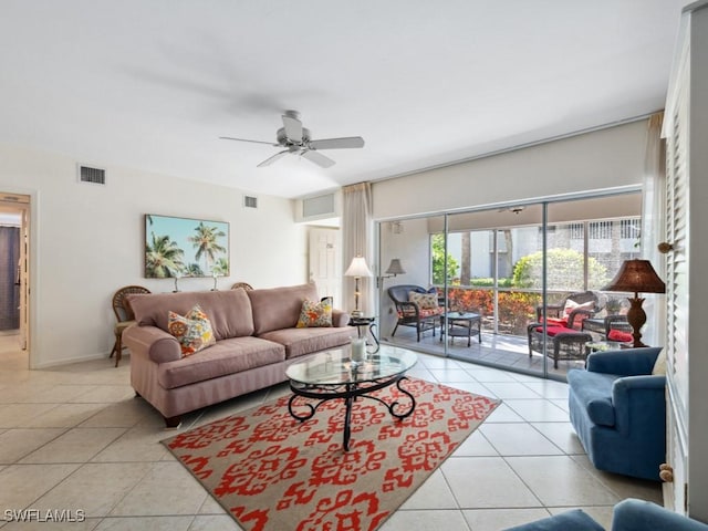 living area featuring baseboards, light tile patterned floors, ceiling fan, and visible vents