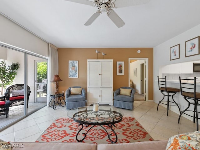 living area with light tile patterned floors and ceiling fan