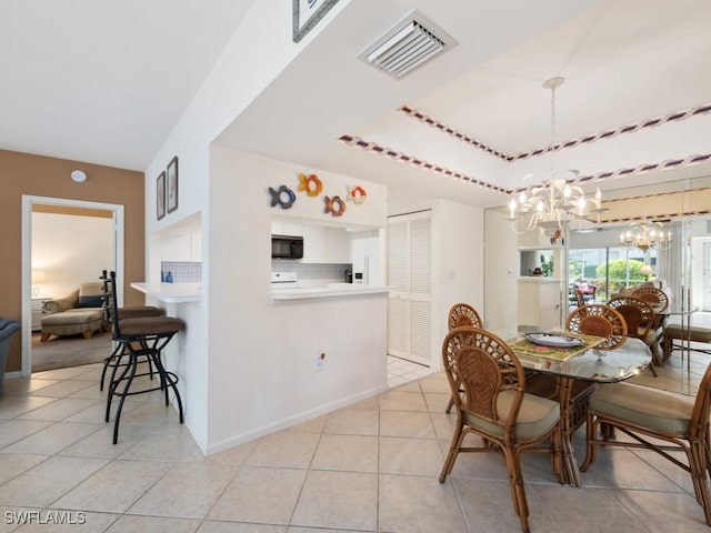 dining room with visible vents, a tray ceiling, a notable chandelier, and light tile patterned floors